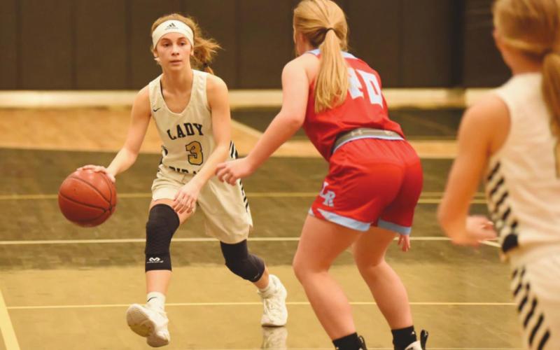 Jana Baters looks for an opportunity as she dribbles past a Lady Raider.