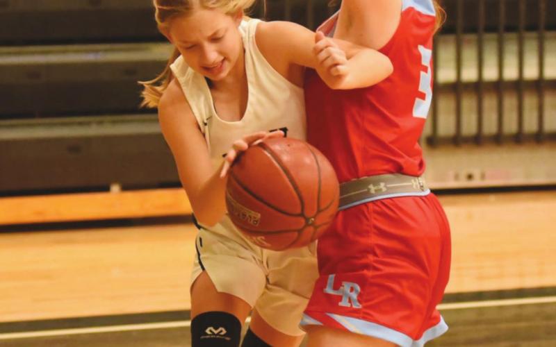 Mia Robin squeezes past a Lady Raider in Friday’s game.