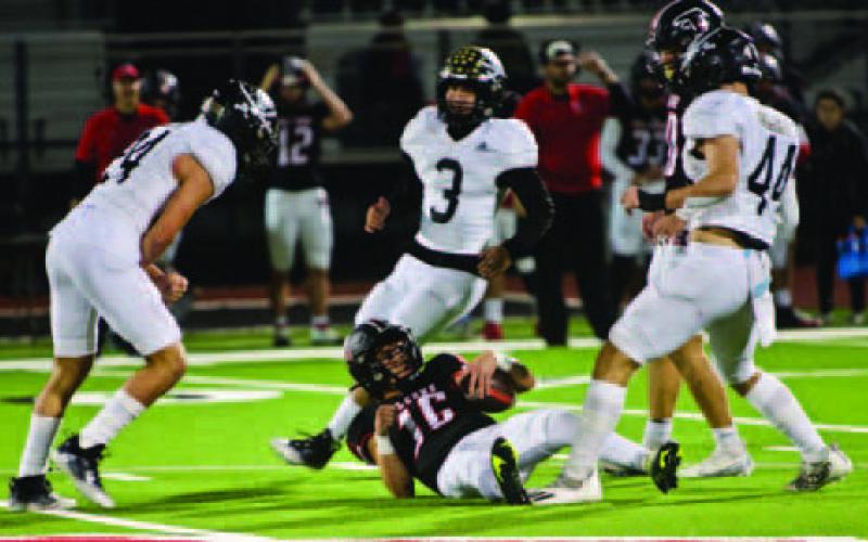 Pirate defenders Jarrett Odom, #24, Kruz Lozano #3, and Tate Ardis, #44, surround the Falcon QB after a loss of yardage.