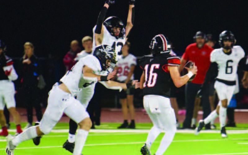 Tate Ardis goes low while Brayden Root got high as they close in on the Huffman quarterback Friday.