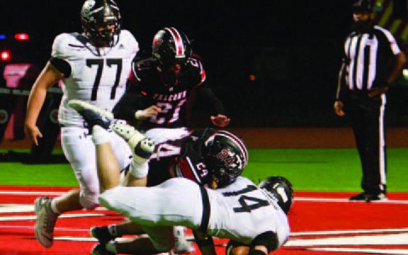 Watson makes a dining touchdown against the Hargrave Falcons. Also pictured is Pirate lineman William Jones.