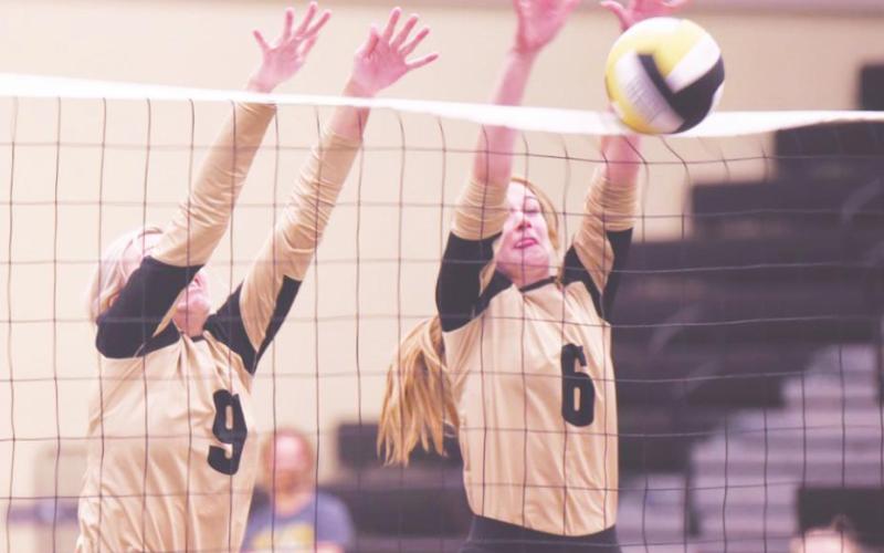 Kennedy Ardis, left, and Brooklyn Bushelle get their hands up in the Lady Pirates’ varsity game versus Deweyville Friday. Busine