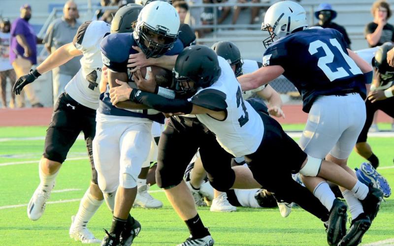 Aiden Villafano stretches to bring down a WOS Mustang runner in Wednesday’s scrimmage.