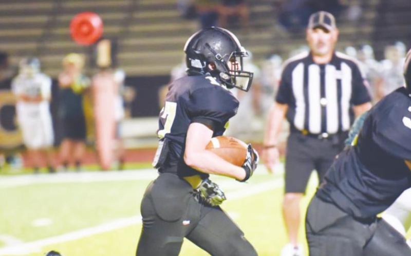 Grant McWherter, center, picks up a first down and more as #3, Jaecob Titman and #25 Trent Korman run interference. Photo by Randall Luker