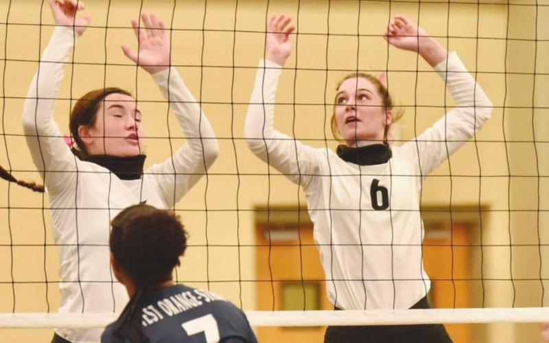 Lady Pirates Ava Lightfoot, left, and Brooklyn Bushelle in action at the net in Saturday’s home game versus the Lady Mustangs.