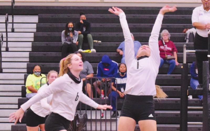 Lady Pirate Brooklyn Healy, right, sets the ball for Brooklyn Bushelle in the Lady Pirates game Saturday versus the WO-S Lady Mustangs.