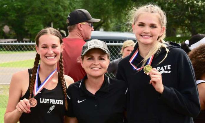 Vidor Head Girls Track Coach Tracy Maines, center, poses with two of Vidor’s district champions, Jaden Lee, left, and Raegan Stephenson, right.