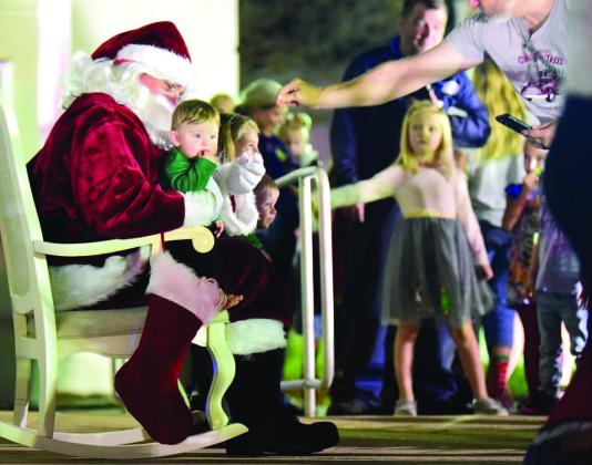 The wonderment of Christmas could be seen in the eyes of children as they lined up to talk to Santa and sit on his lap for a photograph at Vidor City Hall Friday. Photo by Randall Luker