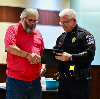 Vidor Police Chief Rod Carroll presents a plaque as he bids farewell to Officer Eric Meineke who is retiring after 13 years of service at the department.