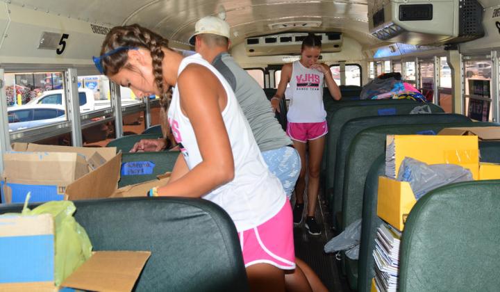 Student volunteers sort and stack the generous school supply donations at the Fill the Bus event. Photo by Randall Luker