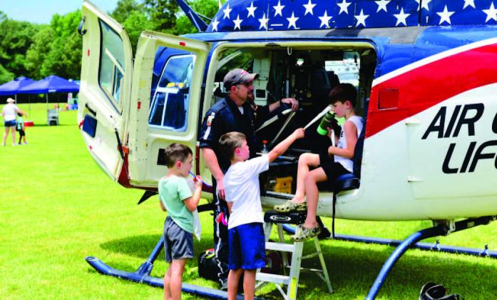 The 27th Annual Cops N Kids Picnic is set for June 9 with local first responders showcasing their tools of the trade and offering up close looks at their equipment in a personal and friendly environment. The annual event also offers lunch, rides, games, all free. In this photo from the 2022 event, children view a medical rescue helicopter and talk with the pilot. Photo by Randall Luker