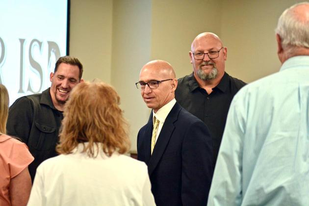Dwayne Dubois, center, is congratulated after being named Vidor’s new Athletic Director/ Head Coach at Monday’s VISD Board of Trustees meeting held in the new Administration Building. Dubois said he was ready to get to work “as soon as possible”. Officially, his contract begins in July. Photo by Randall Luker