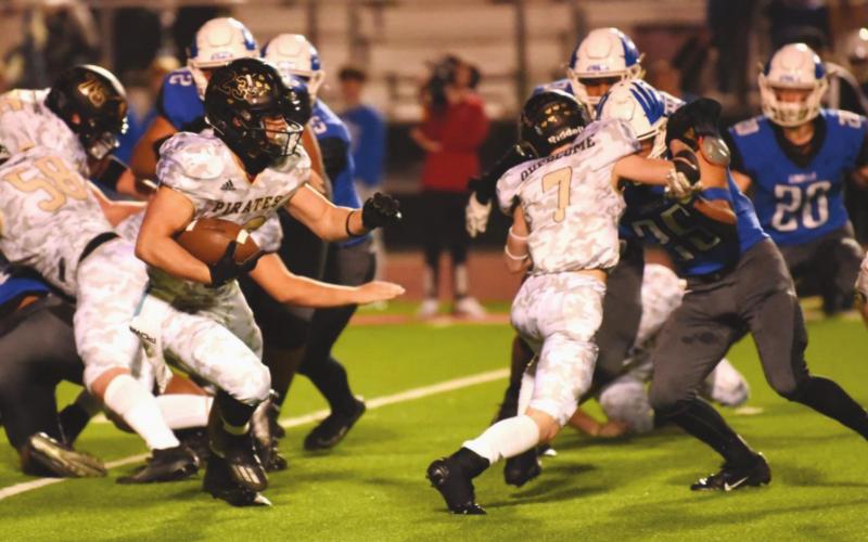 Trenton Conn carries the ball as blockers Weston Sepulvado, #7, Caiden Veazey, #58 and Aaron Aery, #75 , block to his from and rear.