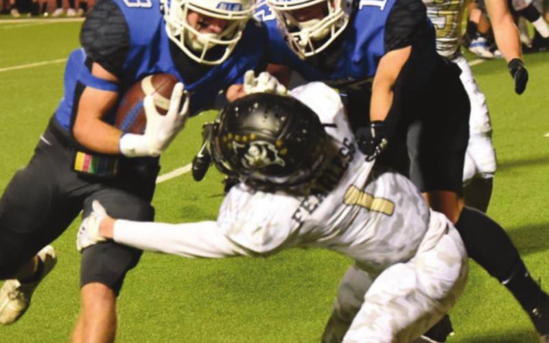 Nathan Bullard reaches out to tackle Jacob Seekford as Daniel Franke blocks.
