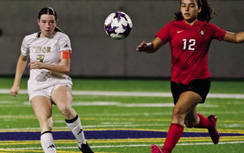 Chloe Post watches her kick as she sends the ball to another Lady Pirate.