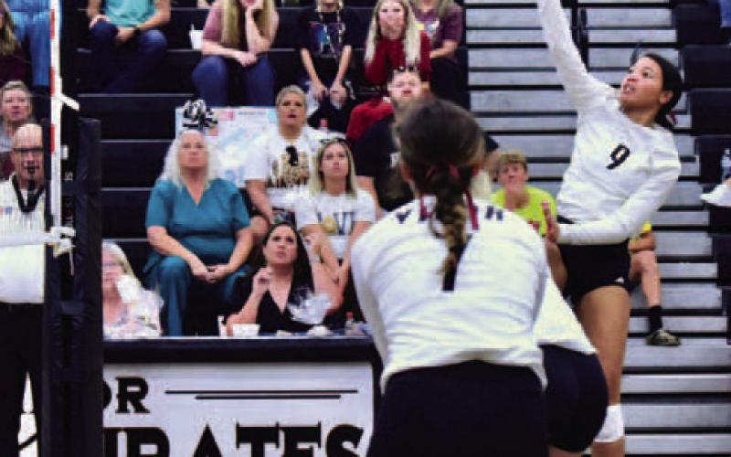 Madison Jones hits a return in the Lady Pirates district opener.  Photo by Randall Luker