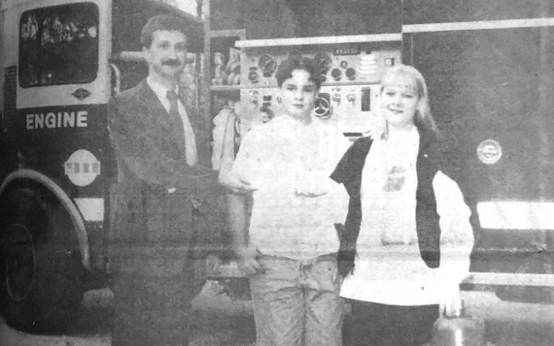 The children of Buz and Lisa Kemp are the first participants in the Orange County Emergency Services District #1's Adopt-A-Hydrant project. The adopted a hydrant in the West Circle Drive neighborhood last week. Fire Chief Scott Kerwood is shown presenting the Kemps with a certificate making the adoption official. Archive Photo