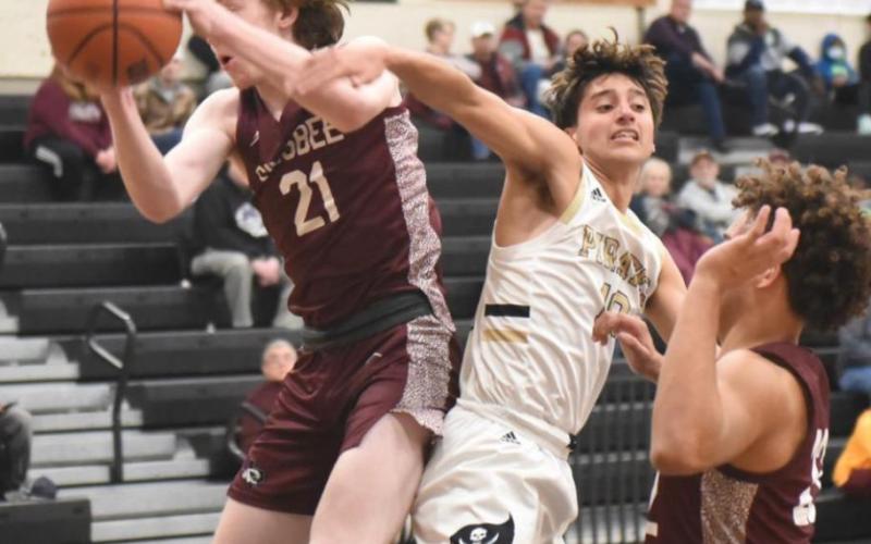 Varsity Pirate Aiden Ochoa fights for possession under the net.