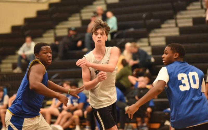 Photo by Randall Luker Colby Eaves passes the ball while surrounded by Bulldogs.