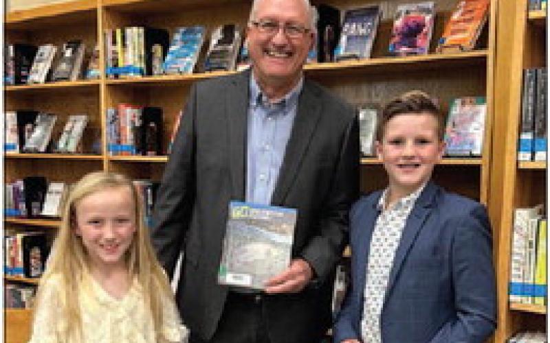 Pine Forest students Caddi Gibbs and Brody Miller honored School Board Vice President Rollie Burr.