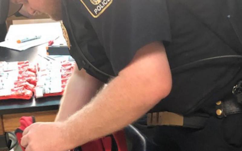 Officer Aaron Carter prepares the emergency backpack. Color Copie
