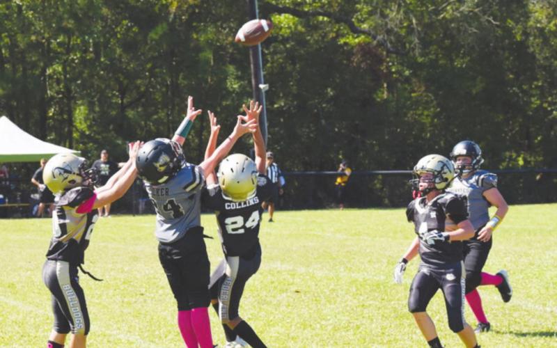 VPIFA Senior League #24 Bryce Walker jumps for a pass between Nederland defenders Saturday.
