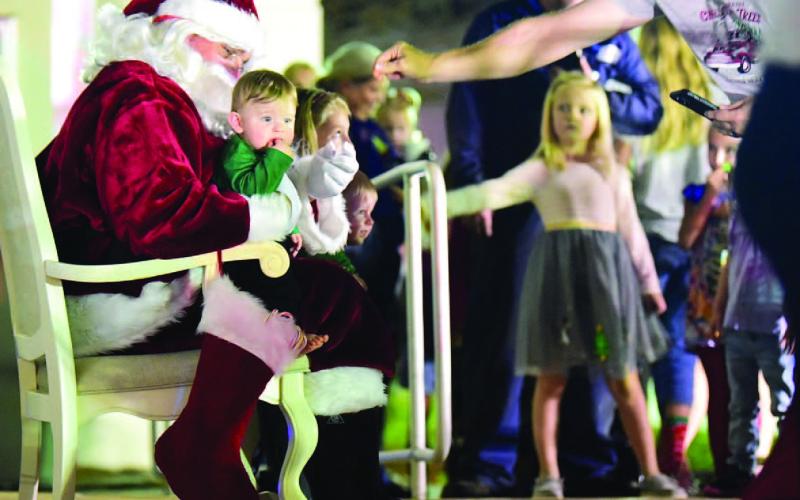 The wonderment of Christmas could be seen in the eyes of children as they lined up to talk to Santa and sit on his lap for a photograph at Vidor City Hall Friday. Photo by Randall Luker