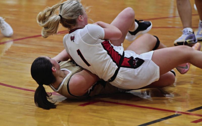 Aubri Frasier battles a Deweyville Lady Pirate for possession.