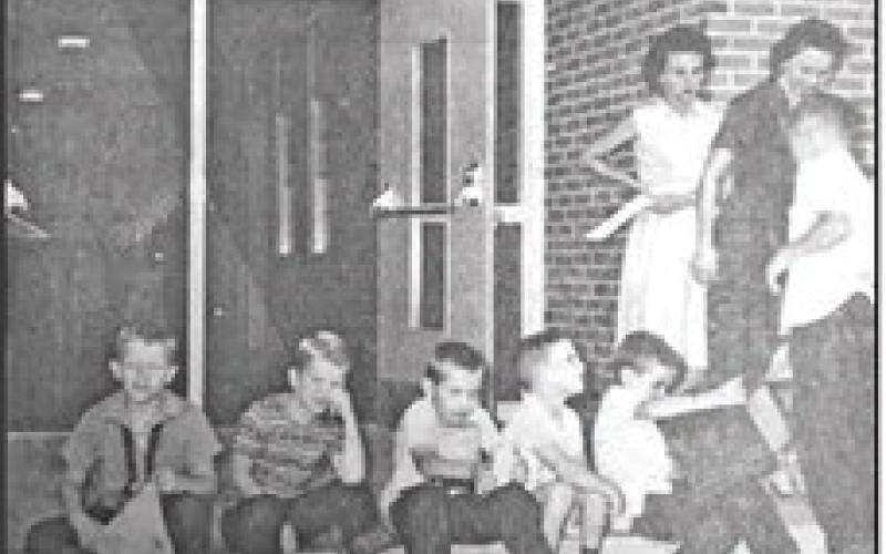 DEJECTION, DISGUST, MIRTH, AND ANTICIPATION, are all expressed on the faces of the youngsters shown in the picture taken on the first day of school at Pine Forest Elementary. According to Mrs. Arlen Portie, principal, registration went well, despite the 'exhausted' looks on the faces of some students shown in the above picture. The only students identified are (l to r) Buddy and Arlos Bennet. (September 10, 1963 issue)