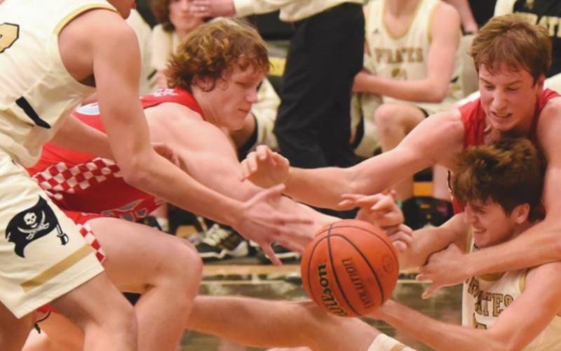 A Lumberton Raider almost has Pirate Joe Gardenhire in a headlock as teammate Dayton Whitmire reaches for the loose ball in Tuesday’s game.