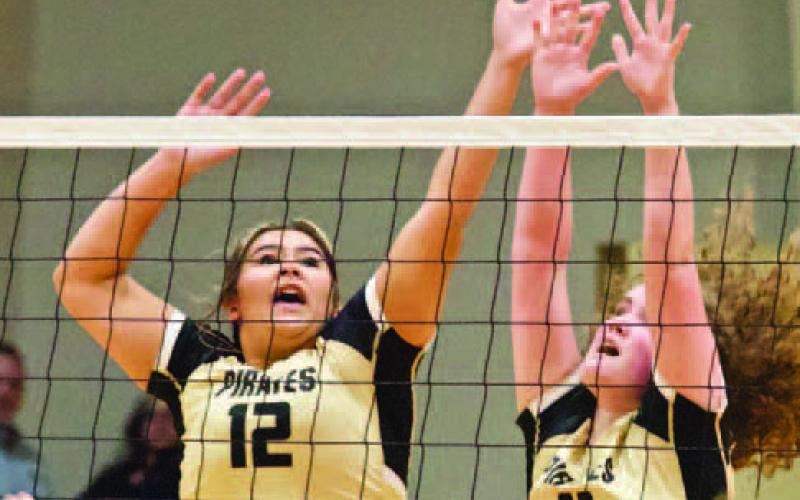 Lady Pirates Laikyn Brodnax #12 and Rylee Sherman #11 jump for a block in Tuesday’s playoff game versus the Lady Hawks. Photo by Randall Luker
