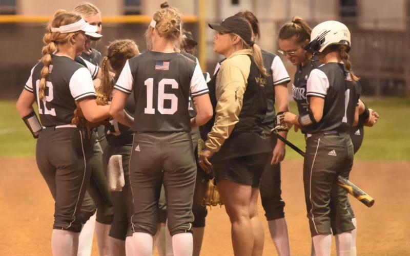 Coach Nikki Trahan talks things over with the Lady Pirates between innings at Friday’s Bridge City game. Photo by Randall Luker