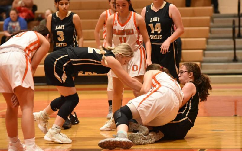 Lady Pirates Dora Rohrbach, on the floor, and Jaelyn Justice, second from left, struggle with a Lady Bobcat for control of the ball. Lady Pirates Natasha Kelley, #3 and Carlie Abbott, #14, are also pictured.