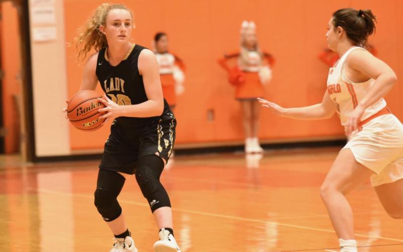 Natalie Morrison looks for an open teammate as a Lady Bobcat rushes in.