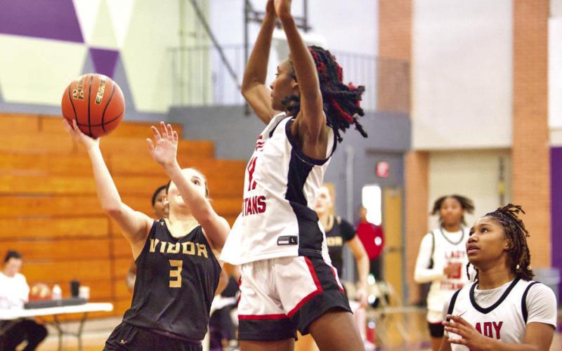 Blocked Vidor’s Allie Williams looks to shoot as a Memorial Lady Titan jumps to block her shot Saturday in the Championship Game of the PNG Tournament.
