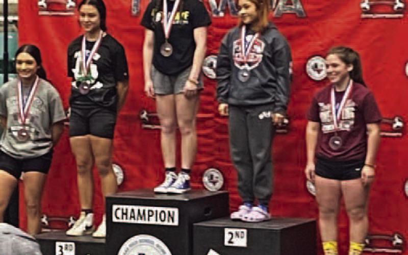 Camryn Barragan, center, set a new state record with a 250 pound lift in bench press in the 123 weight class at the Girls State Powerlifting Meet last week. the previous record was 215 pounds. Vidor’s team placed 4th at the state meet. Photo by Randall Luker