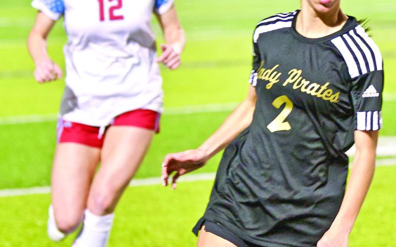 Hugging the sideline Taylor Bull moves the ball into Lady Raider territory in Tuesday night’s district game with Lumberton.