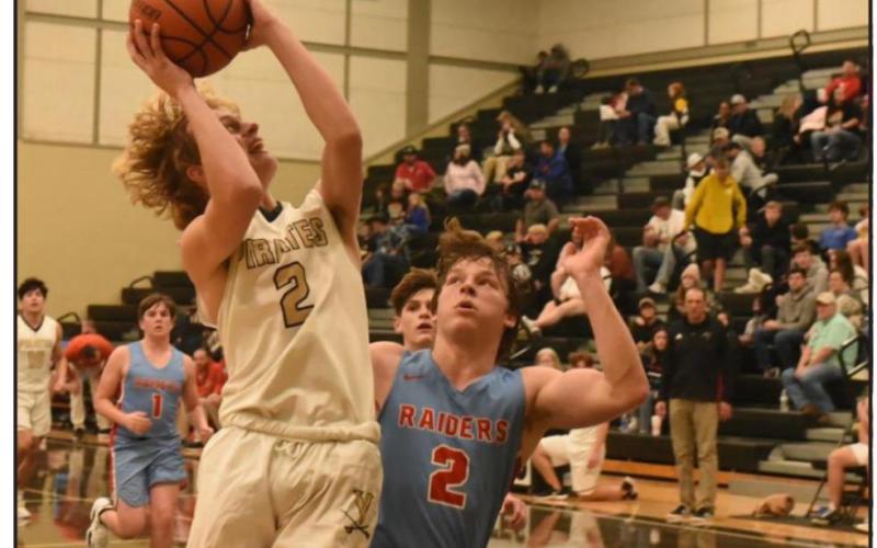 Junior varsity Pirate Brody Wright out jumps a Raider to shoot. Photo by Randall Luker