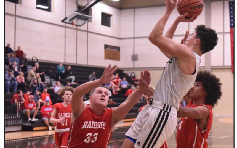 Freshman Dallas Pachuca shoots for two between Lumberton defenders. Vidor defeated Lumberton 43-36 in the district matchup. Photo by Randall Luker