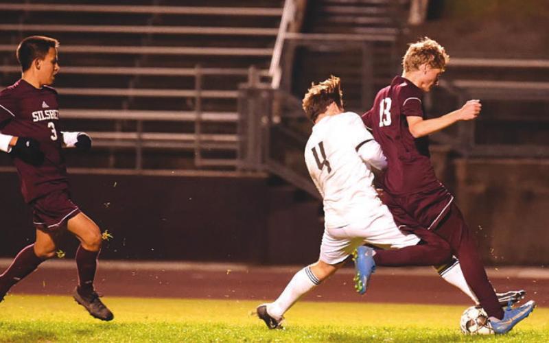 Alex Ramos battles a Silsbee Tiger for possession. Photo by Randall Luker