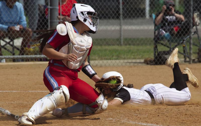 Tyler Cassell slides by the Lady Raider catcher to add a run to Vidor score Tuesday in Vidor. The Lady Pirates stage a come from behind rally to beat Lumberton 13-9.