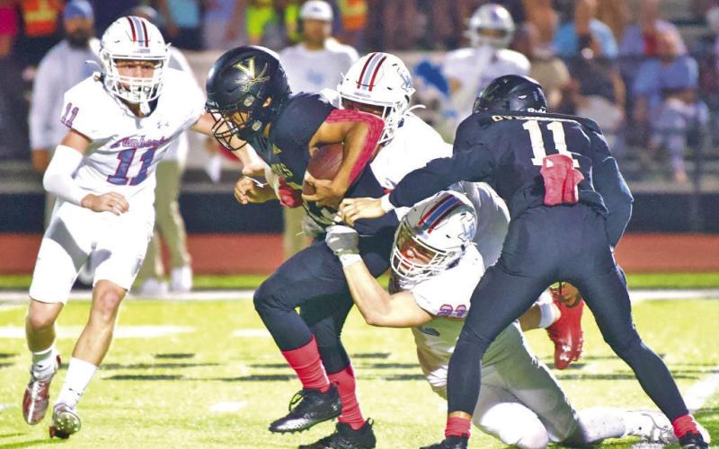 Jayden Jones gains extra yards as he drags a pair of Raiders as team mate Bryce Dubose lends a hand.