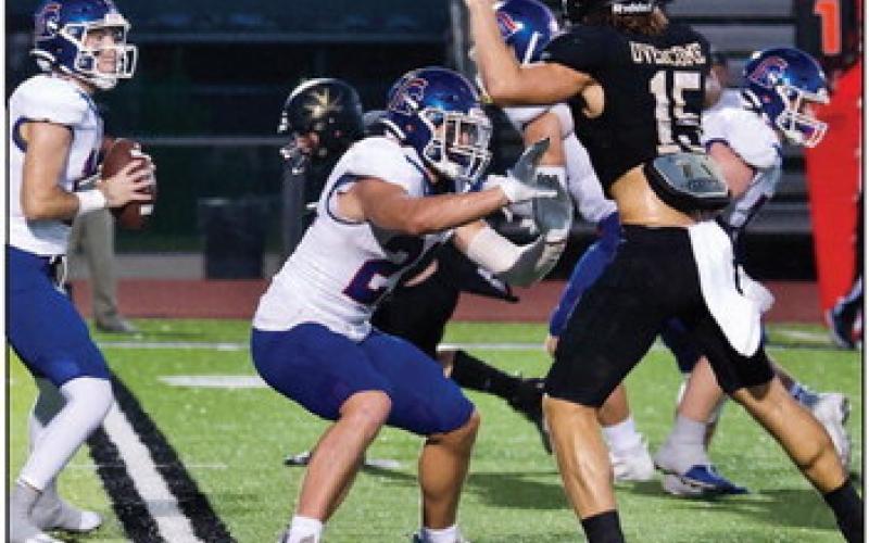 Blayden Laughling, #15, and Grant McWherter, #34, pressure the Trojan quarterback. Photo by Randall Luker