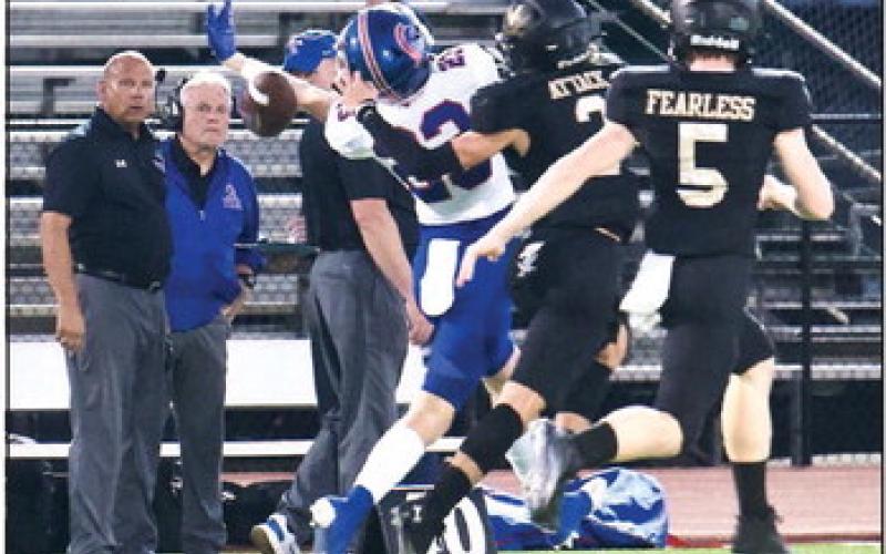 Blake Richards, #2, and Braden Norton, #5, break up a Trojan pass. Photo by Randall Luker