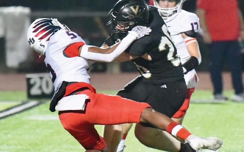 Pirate RB Riley Marlow is hard to tackle as a hawk defender tries to find a grip.