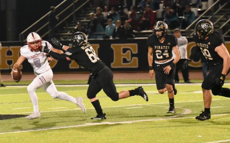 Photo by Randall Luker Tyler Rojas, #68, Jarrett Odom, #24 and Jordan Smith, #99, bring the heat to the Lumberton QB in the Pirates’ 28-27 win Friday.
