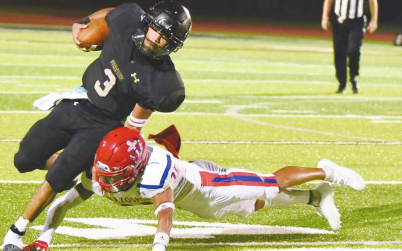 Pirate quarterback Quinten Root avoids a tackle as he cuts upfield against the Brazosport Exporters Friday.
