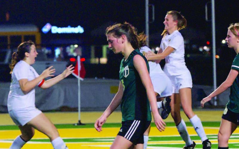 Lady Pirates Alaina Davis, left, and Jaden Lee, in white jersey right, begin the celebration as they react to Kenya Correia’s game winning goal as the Lady Bears’ expressions reflect their disappointment. Photo by Randall Luker