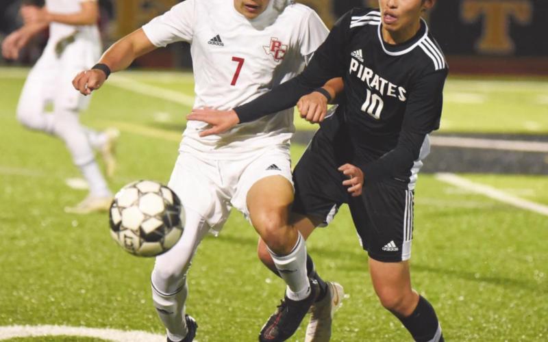 Pirate Ryan Liu battles a Bridge City Cardinal for control of the ball in Friday’s game.