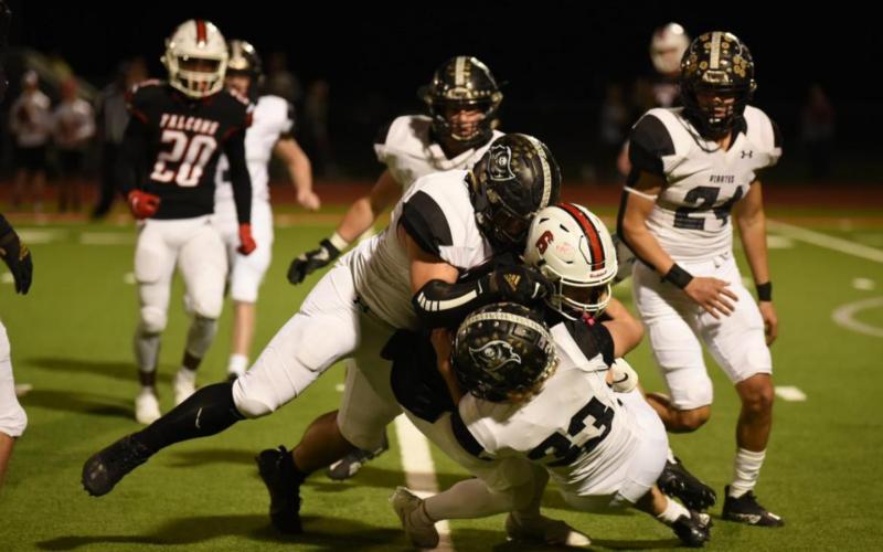 Jordan Smith and Connor McKay, #33, wrap up a Falcon ball carrier for a loss of yardage. Photo by Randall Luker